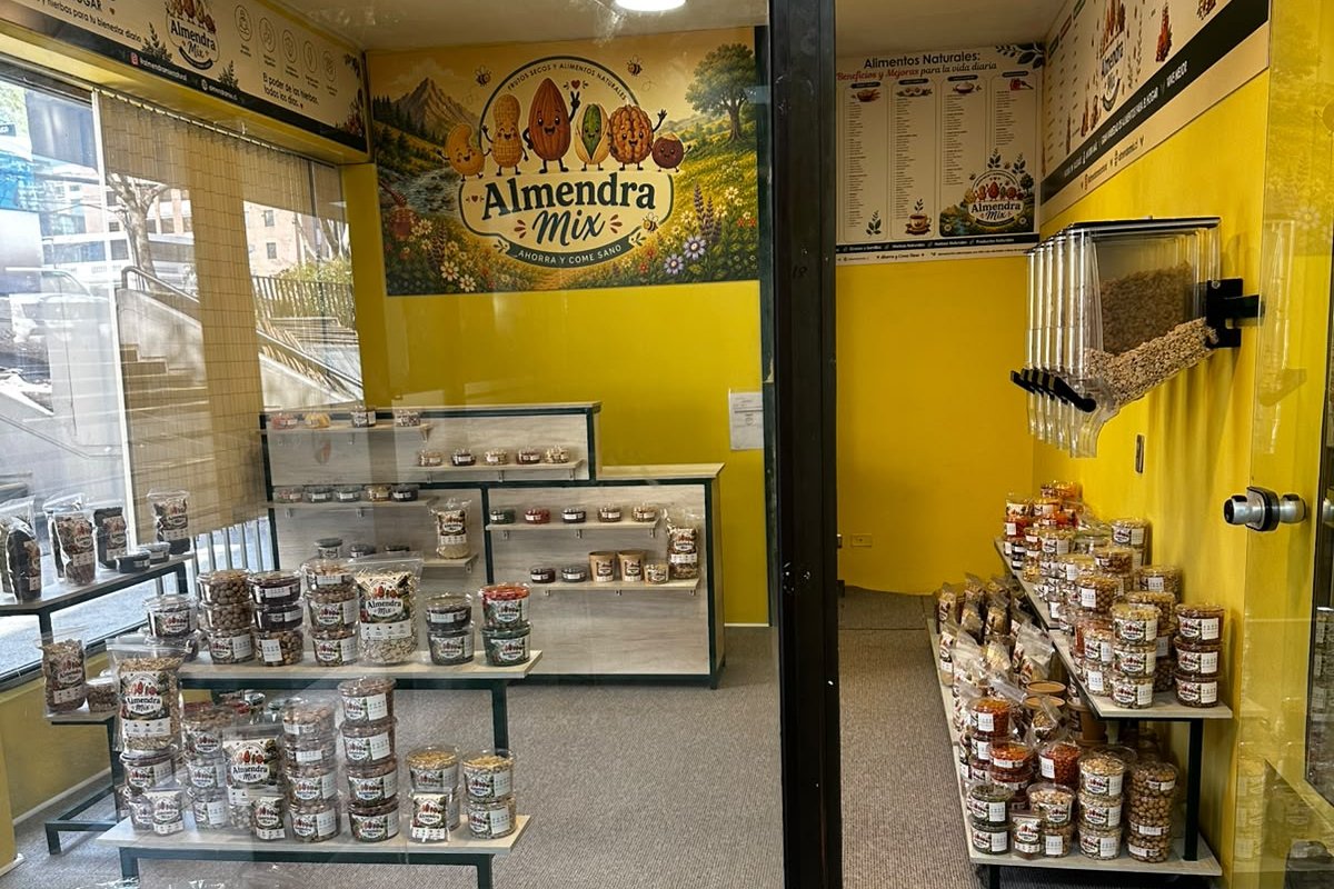 Vitrina de la tienda de Almendra Mix en Las Condes, con las repisas de potes y bolsas y el mural de la marca al fondo